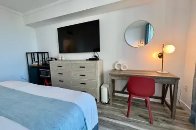 a bedroom with a bed and a desk with a mirror at Balcony Ocean View ! Pool - WiFi - Gym - Parking in Miami