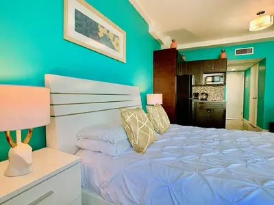 a bedroom with a bed and a blue wall at Directly on the Beach with Pool & Ocean View in Miami Beach