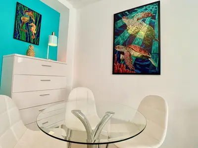 a dining room with a glass table and white chairs at Directly on the Beach with Pool & Ocean View in Miami Beach