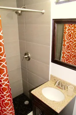 a bathroom with a sink and a shower with a mirror at Directly on the Beach with Pool & Ocean View in Miami Beach