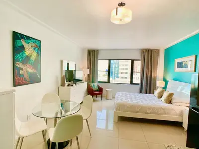a bedroom with a bed and a glass table at Directly on the Beach with Pool & Ocean View in Miami Beach