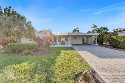 a house with a garden and a driveway at Gorgeous poolhome on the canal in Fort Lauderdale