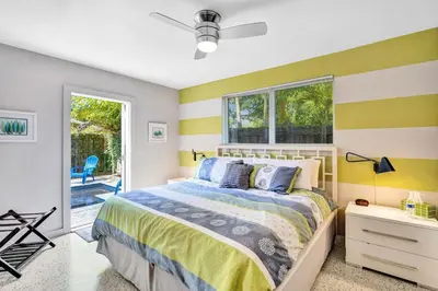 a bedroom with a bed with yellow and white stripes at 3bed 2bath with pool, 5 min. walk to food and fun in Fort Lauderdale