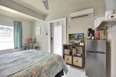 a bedroom with a bed and a refrigerator and a table at Private studio, 5 min. walk to Wilton Drive in Fort Lauderdale