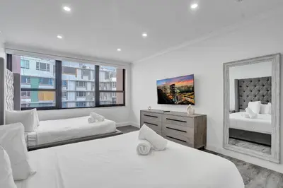 a white bedroom with two beds and a mirror at Ocean View 2BD Penthouse Beach Service PH-6 in Miami Beach