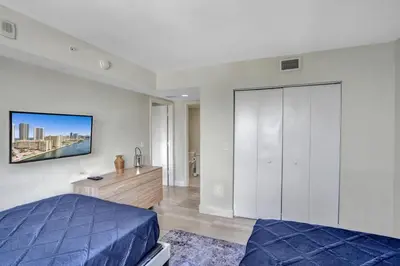 a bedroom with a bed and a dresser at Spacious Luxury Ocean View 4 Bdrs 3Baths 17 FL in Hallandale Beach