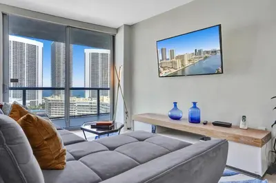 a living room with a couch and a large window at Spacious Luxury Ocean View 4 Bdrs 3Baths 17 FL in Hallandale Beach