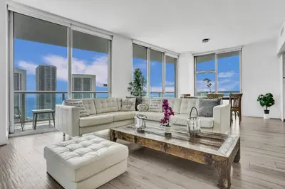 a living room with a couch and a table at Lower Penthouse 3BD 3BA Beach Gym and Pool in Hallandale Beach