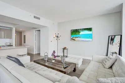 a living room with a white couch and a table at Lower Penthouse 3BD 3BA Beach Gym and Pool in Hallandale Beach