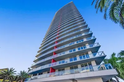 a tall building with a red stripe on it at Upscale Resort 4 Bedrooms 3 bath in Hallandale Beach