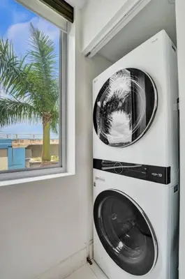 a washer and dryer in a room with a window at Upscale Resort 4 Bedrooms 3 bath in Hallandale Beach