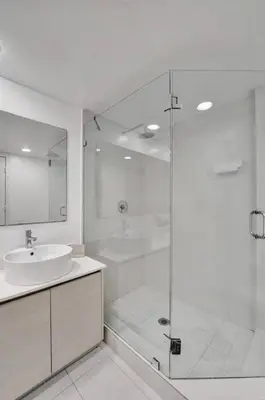 a white bathroom with a shower and a sink at Upscale Resort 4 Bedrooms 3 bath in Hallandale Beach