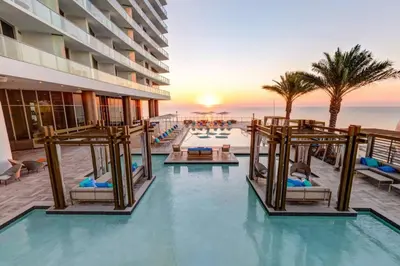 a resort pool with chairs and the ocean in the background at Oceanfront Condo Direct Ocean View Beach Access in Hollywood