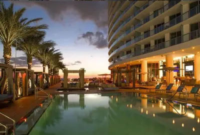a hotel with a swimming pool in front of a building at Oceanfront Condo Direct Ocean View Beach Access in Hollywood
