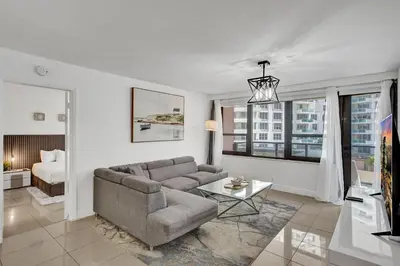 a living room with a couch and a bed at Oceanfront condo beach service 411 in Miami Beach