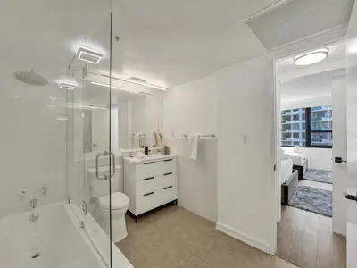 a white bathroom with a shower and a toilet at Cute Ocean View Condo Beach Service 1217 in Miami Beach