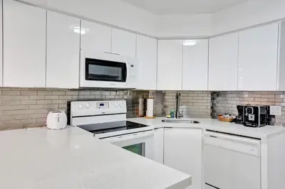 a white kitchen with white appliances and a microwave at Spacious Ocean View Resort Beach Condo 601 in Miami Beach