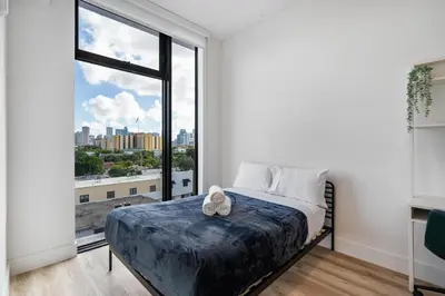 a bedroom with a bed and a large window at Pastel Apartments in Miami