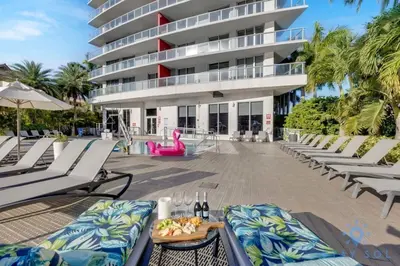 a resort with lounge chairs and a building at Resort Near Beach with Amazing Pool and Gym in Hallandale Beach