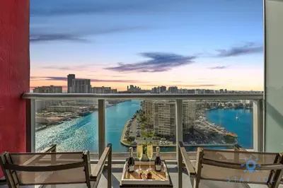 a balcony with chairs and a view of the ocean at Beachwalk - Sun, Amazing Pools and Gym in Hallandale Beach