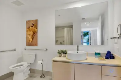 a white bathroom with a toilet and a sink at Apartment with Balcony - Pool- Near Beach in Hallandale Beach