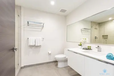 a white bathroom with a toilet and a sink at The Most Liked Homes Hot tub & Unique Rooftop in Hollywood