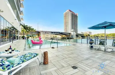 an outdoor patio with a pool and a building at Luxury 3 BR Stunning View & High Floor Hot Tub in Hollywood