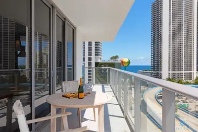 a balcony with a table and a bottle of wine at Wrap Around Balcony-Awesome View-Amazing Pools in Hollywood