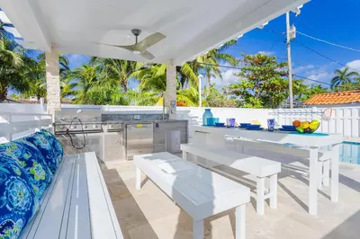 an outdoor kitchen with white furniture and a table at WALK to Hollywood Beach Spectacular 5BR and 5BA Villa in Hollywood