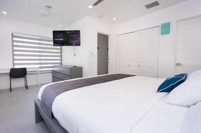 a white bedroom with a large bed and a television at WALK to Hollywood Beach Spectacular 5BR and 5BA Villa in Hollywood