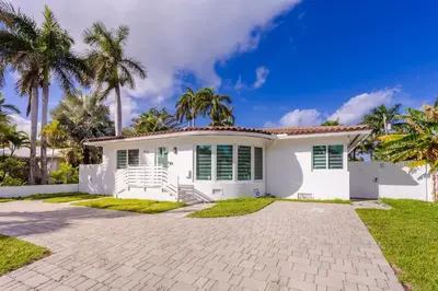 a white house with palm trees in the background at WALK to Hollywood Beach Spectacular 5BR and 5BA Villa in Hollywood