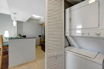 a kitchen with a refrigerator and a room with a table at Beachfront with direct beach access and amazing views in Aventura