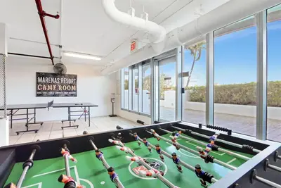 a room with a pool table with people in it at Beachfront with direct beach access and amazing views in Aventura