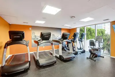 a gym with a bunch of cardio equipment in a room at Beachfront with direct beach access and amazing views in Aventura