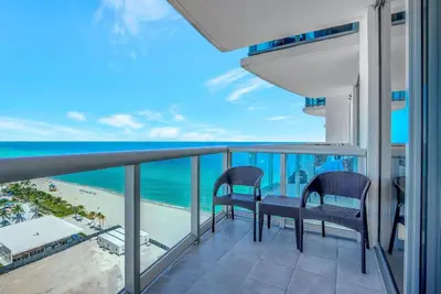 a balcony with two chairs and a view of the ocean at Beachfront with direct beach access and amazing views in Aventura