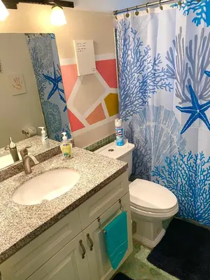 a bathroom with a sink and a toilet and a shower curtain at Judit’s in Dania in Dania Beach