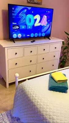 a dresser with a television on top of it at Judit’s in Dania in Dania Beach