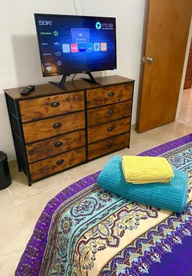 a tv on top of a dresser with a bed at Judit’s in Dania in Dania Beach