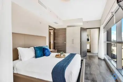 a bedroom with a large white bed with blue pillows at Condo Bay View Infinity Pool Beach Service in Hollywood