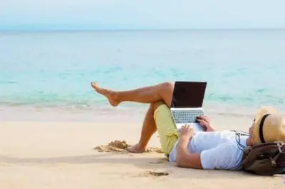 a man laying on the beach with a laptop at Condo Bay View Infinity Pool Beach Service in Hollywood