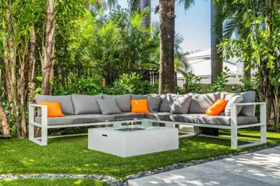 a couch sitting on the grass in a yard at Villa Loggia Oasis Luxurious 6BD ,7BA with Resort Style Pool in Golden Beach