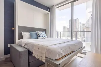 a bedroom with a bed and a large window at Boutique Condo in DT Miami Perfect for Couples/Fam in Miami