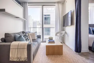 a living room with a couch and a large window at Boutique Condo in DT Miami Perfect for Couples/Fam in Miami