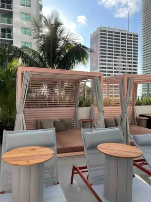a patio with two tables and chairs on a roof at Boutique Condo in DT Miami Perfect for Couples/Fam in Miami