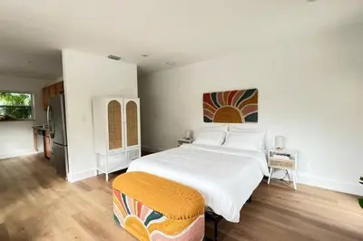 a bedroom with a large white bed and a kitchen at Morning Sunshine @Sailboat Bend in Fort Lauderdale