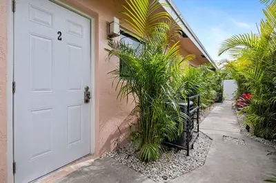 a white door with plants next to a building at Sailors Rest @ Sailboat Bend in Fort Lauderdale
