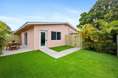a small pink house with a green lawn at Awesome 1BR Apartment @Sailboat in Fort Lauderdale