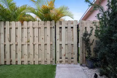a wooden fence with a walkway in front of a yard at Awesome 1BR Apartment @Sailboat in Fort Lauderdale