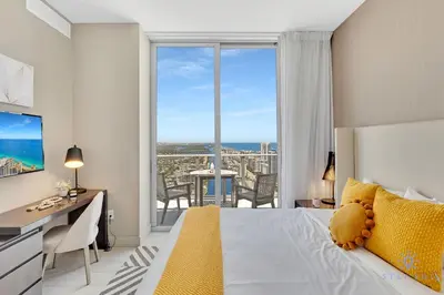 a bedroom with a bed and a desk and a large window at Beach House Design in Hollywood