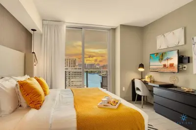 a bedroom with a bed and a desk and a window at Very Chic - Bay View & Balcony - Amazing Pools- Gym in Hollywood